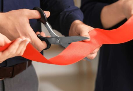 Cutting A red ribbon at an opening ceremony