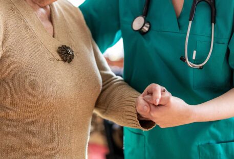 Friendly nurse supporting an elderly lady